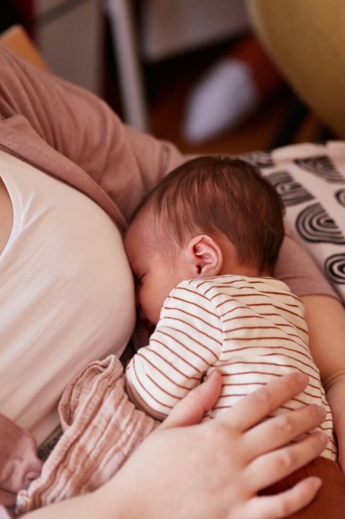 Newborn baby breastfeeding while resting on mother’s chest, symbolizing the emotional challenges and sleep deprivation that inspired my journey as a sleep consultant.